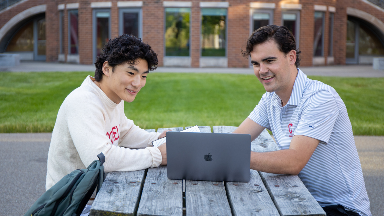 Two male students looking at laptop