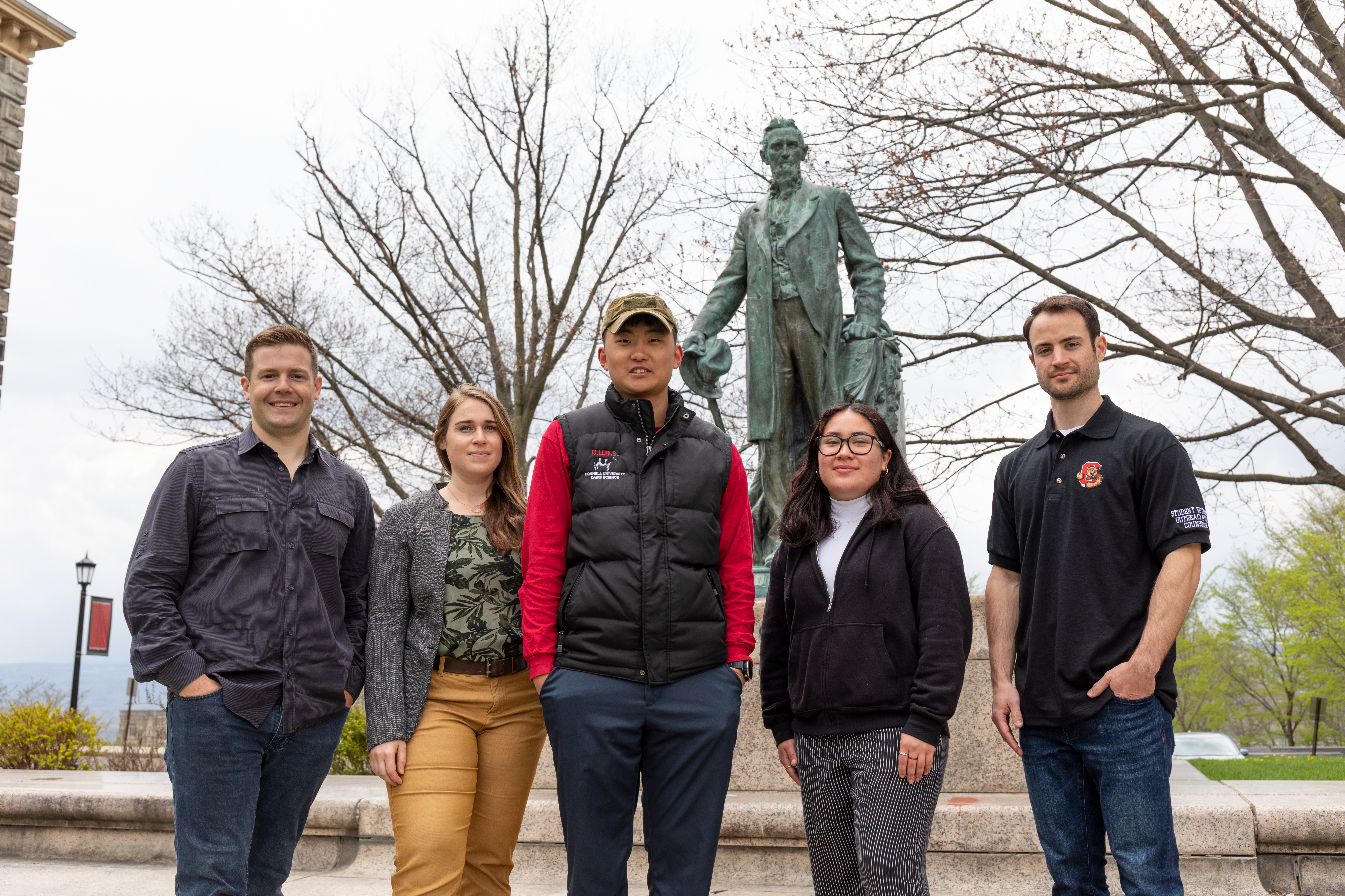 Veteran Students standing in front of Ezra Cornell statue