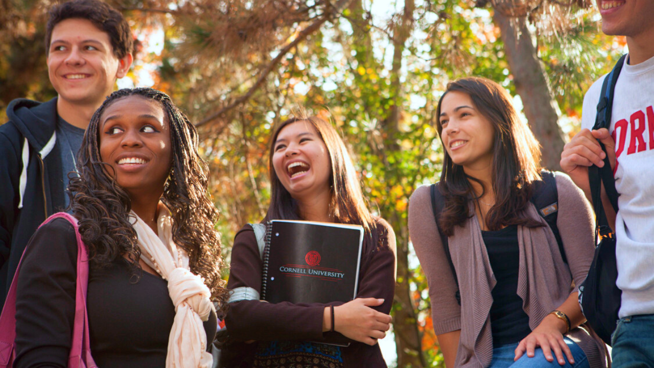 Five students looking off to the side and smiling