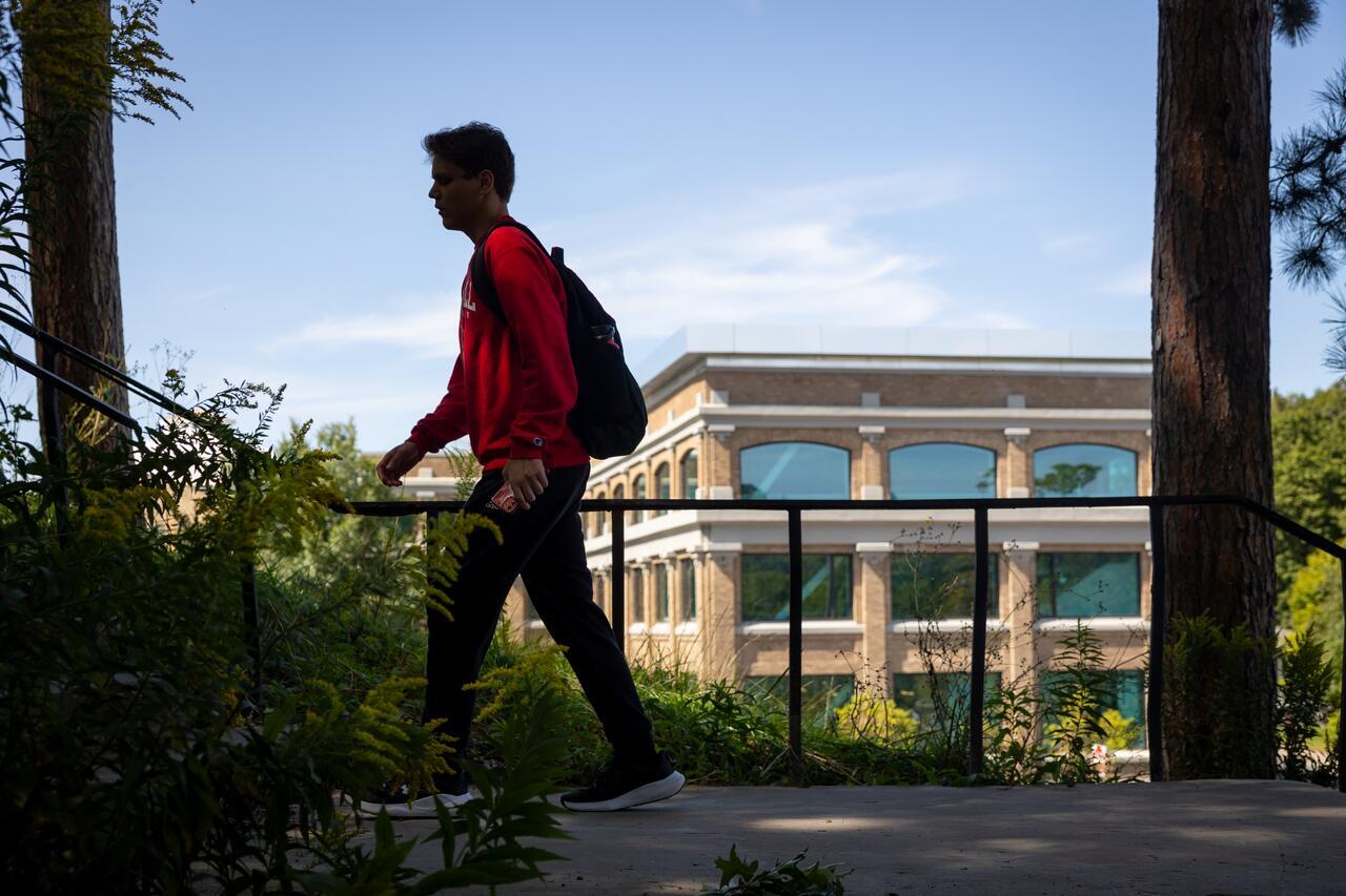 A student climbs the stairs toward Baker Lab with Rand Hall in the background.