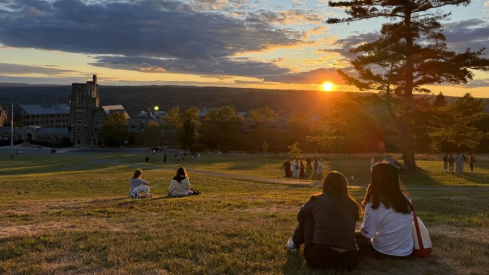 Students watch sunset on the slope.