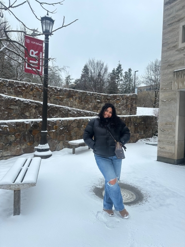 Emely R poses by an ILR flag on a snowy day