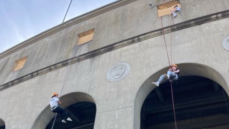 Students descend the outer wall of Schoellkopf Field.