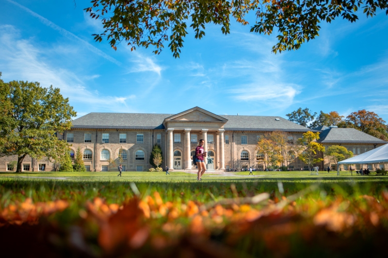 A student walks through the Arts Quad on a sunny day.