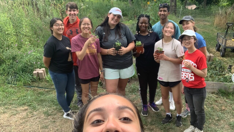 POST participants pose with plants during a community service experience.