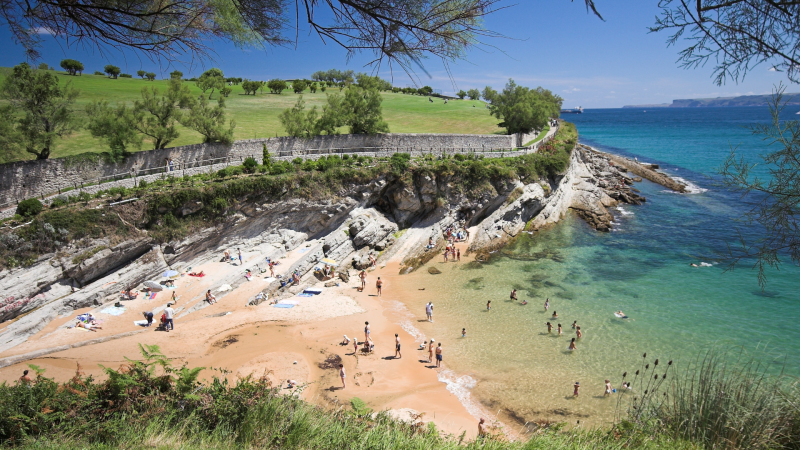People wade at the shore on the northern coast of Spain.