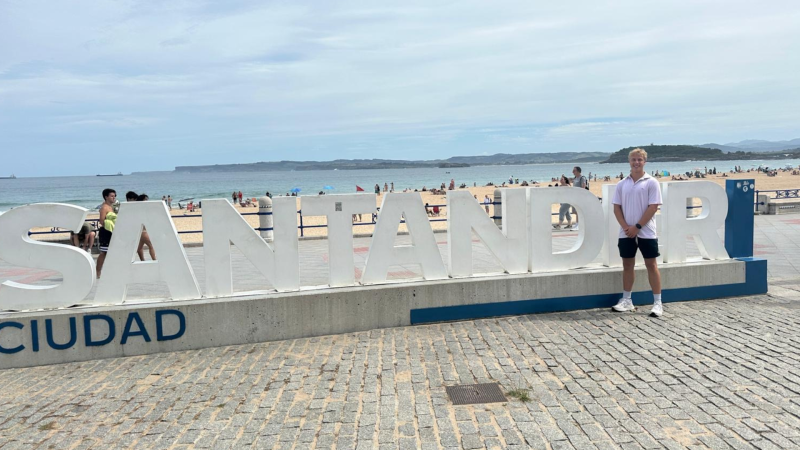 Joe poses by the Santander sign.