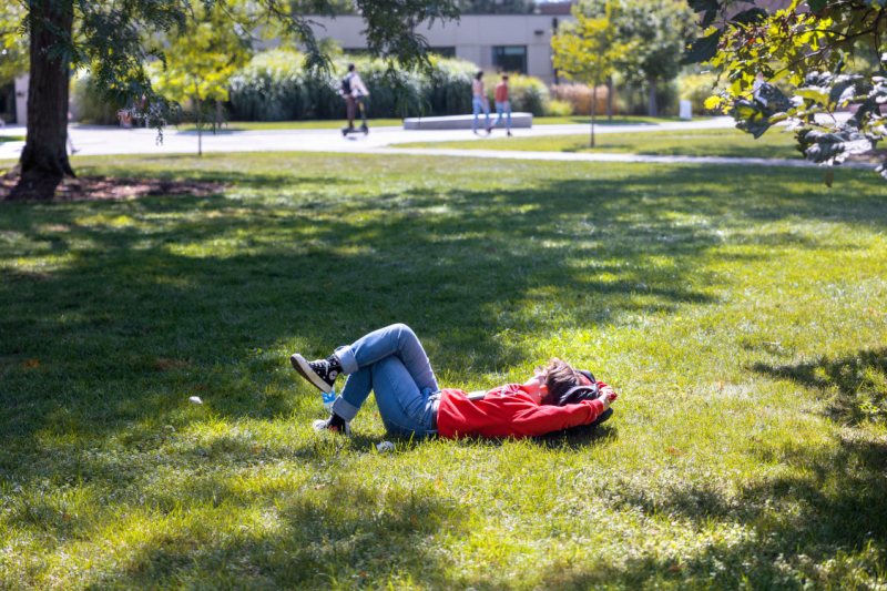 A student soaks up some warm afternoon sun on the Ag Quad.