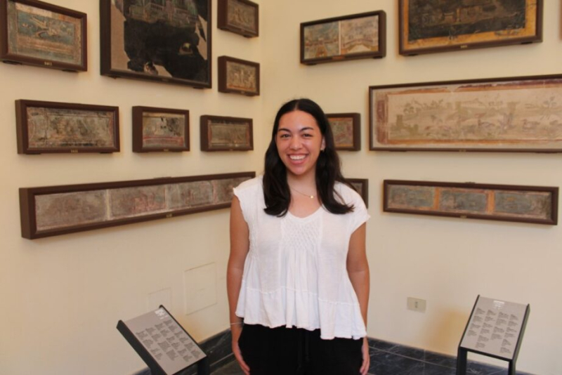 Grace poses in front of art.