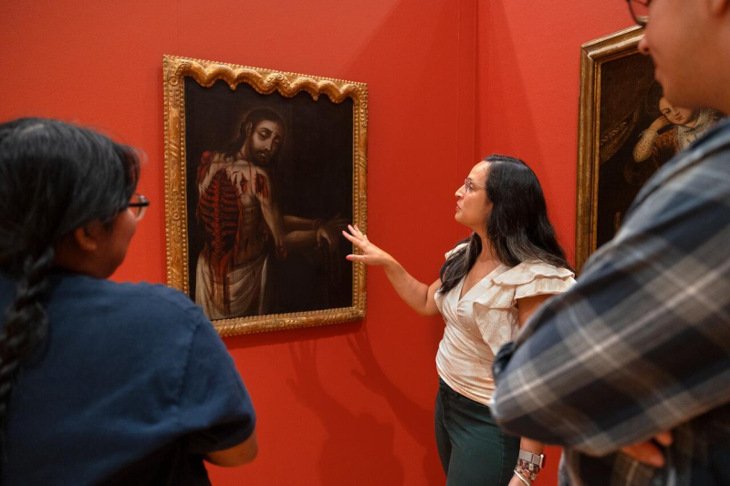 Ananda Cohen-Aponte, associate professor of history of art and visual studies , discusses a painting with students.