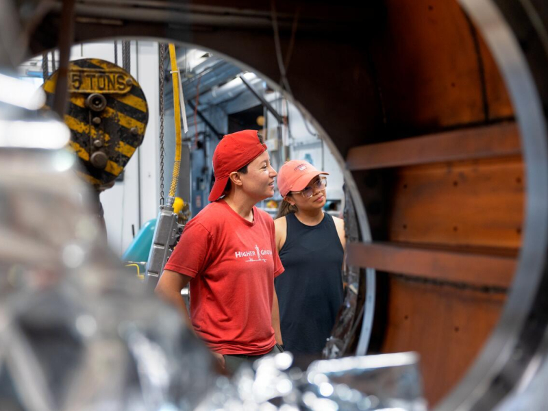 2022 Warrior-Scholar Kristy Callis (left, Marine Corps veteran ) and Ma Sophia Alexis Malate (Rrght, Active Duty Marine Corps) take a tour of the Newman Accelerator Laboratory during their STEM Week classes.