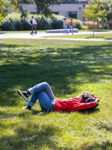 A student soaks up some warm afternoon sun on the Ag Quad.