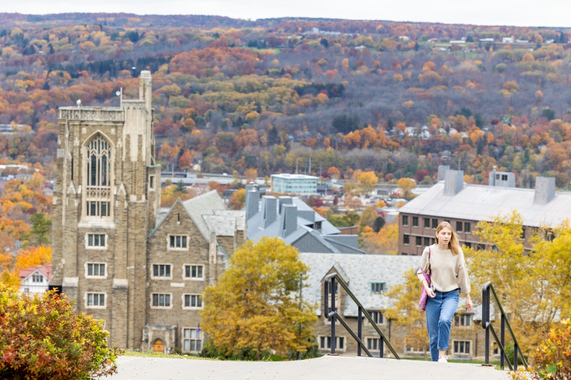 A student walks up Libe Slope from West Campus on an autumn day.